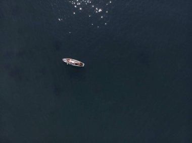 Stand Up Paddle tahtasında çekici bir kadın yemek masasında kürek çeken ve şeffaf suyun tadını çıkaran bir kadın. Tropik seyahat, seyahat tutkusu ve su aktivitesi konsepti. Gün batımı ve rahatlama