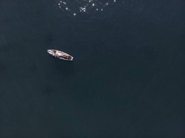 Stand Up Paddle tahtasında çekici bir kadın yemek masasında kürek çeken ve şeffaf suyun tadını çıkaran bir kadın. Tropik seyahat, seyahat tutkusu ve su aktivitesi konsepti. Gün batımı ve rahatlama