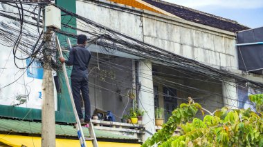Merdiven üzerinde duran elektrikçi 