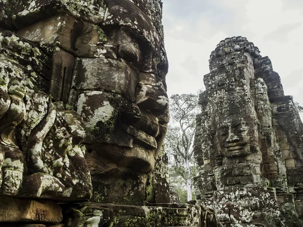 バイヨン寺院アンコール ホワイト バック グラウンド観に直面しています 寺院の遺跡カンボジアのホワイト バック グラウンドを分離 石彫刻組成物の寺院の コピーのテキストのための領域 — ストック写真