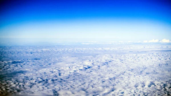 从飞机的窗户看到的云彩和天空 飞过云层 去度假的概念 全景天空从高度在积云和层状层云云彩 — 图库照片