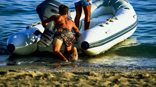 Φουσκωτή βάρκα στην ακρογιαλιά, αμμώδης παραλία. — Φωτογραφία Αρχείου