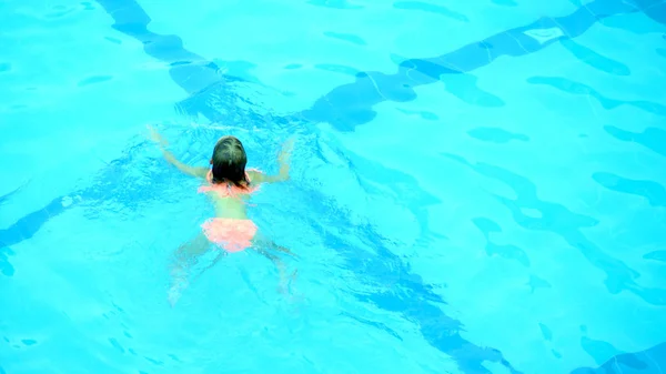 Kleines Mädchen schwimmt im Pool — Stockfoto