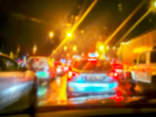 Blurred background : Inside car with bokeh lights from traffic jam on night time for background. Night road. View from inside car. Natural light. Street and other cars is motion blurred.