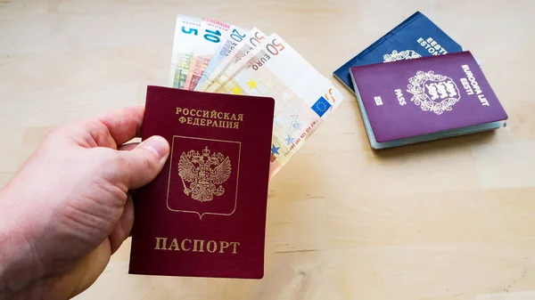 Mão Segurando Passaporte Fundo Madeira Com Dinheiro Cidadania Estónia Rússia — Fotografia de Stock