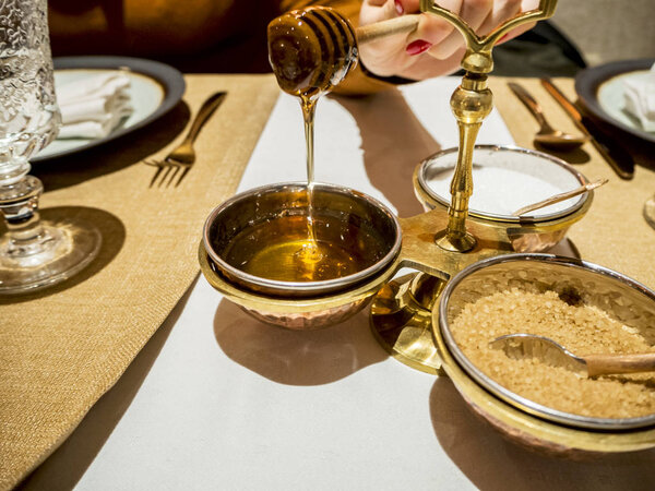 Close up of womans hands taking honey