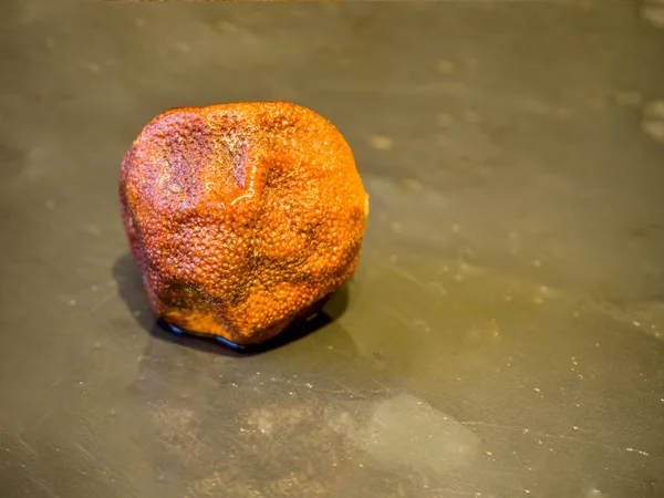 Mandarina podre ob pedra preta — Fotografia de Stock