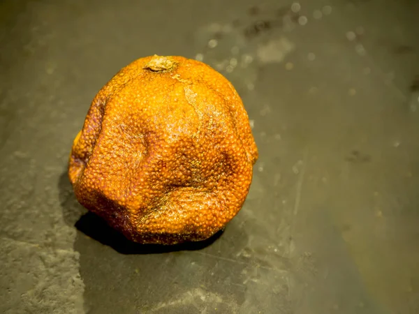 Mandarina podre ob pedra preta — Fotografia de Stock