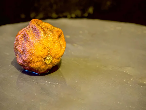 Rohadt mandarin ob fekete kő — Stock Fotó