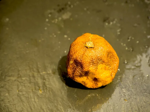 Mandarina podre ob pedra preta — Fotografia de Stock