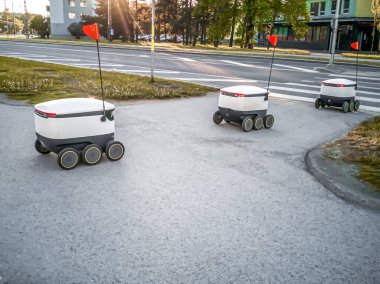 Sokaktaki bazı teslimat robotları. Tallinn City 'deki Estonyalı siber kuryeler. Güneşli yaz günü. 