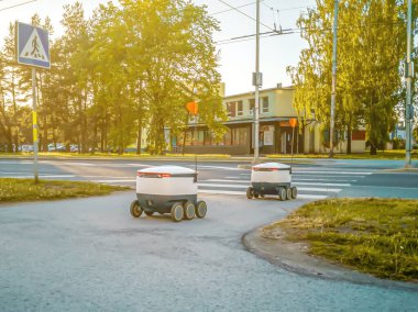 Sokaktaki bazı teslimat robotları. Tallinn City 'deki Estonyalı siber kuryeler. Güneşli yaz günü. 