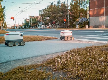 Sokaktaki bazı teslimat robotları. Tallinn City 'deki Estonyalı siber kuryeler. Güneşli yaz günü. 