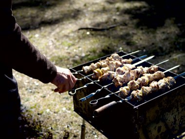 Kızarmış kömür ızgaraya, ızgaraya ve barbeküye hazırlanıyor. Arka planda orman var. Yemeğinizin yerleştirilmesini bekliyorsunuz. Kapatın. tatil kavramı