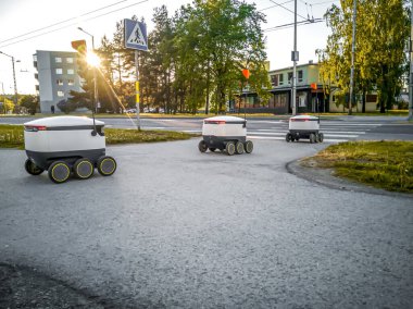 Sokaktaki bazı teslimat robotları. Tallinn City 'deki Estonyalı siber kuryeler. Güneşli bir yaz günü. Uzayı kopyala Üzerine monte edilmiş görüntü. Yeni teknoloji kavramı.