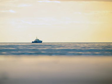 Küçük bir balıkçı teknesi şafak vakti sisli okyanusa açılacak. Günbatımının arka planında bir tekne. Baltık Denizi kapanıyor, fırtınalı, dramatik kara bulutlar. Tatil, yaz konsepti