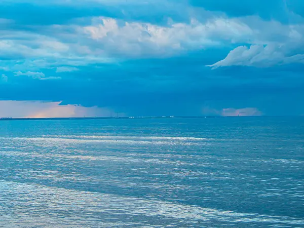 The Baltic Sea at sunset, stormy dramatic clouds. Sunset and dark clouds after storm. The Vacation, summer concept