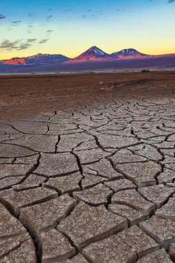Cracked earth and Licancabur volcano at the Atacama Desert. clipart