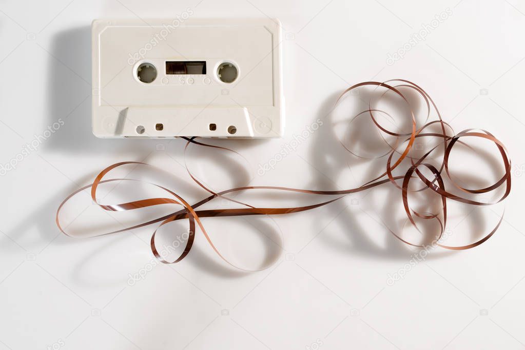 Unraveled cassette tape on white background