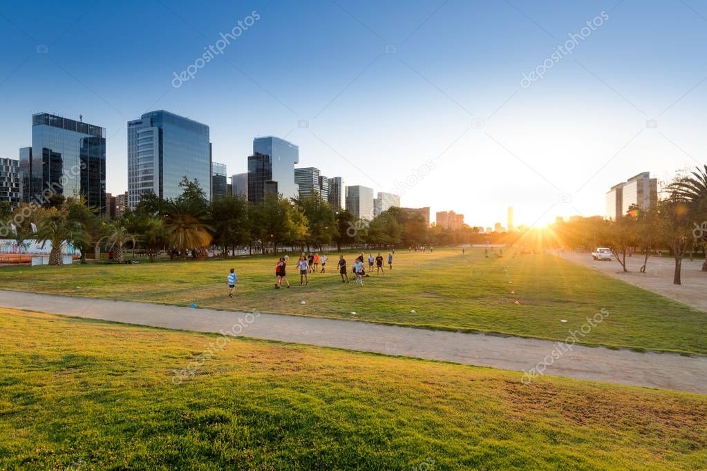 Santiago, Region Metropolitana, Chile - January 17, 2019: People practicing sports at Parque Araucano, the main park in Las Condes district, surrounded by office buildings of Nueva Las Condes business center.