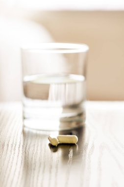 Bir bardak suyun yanında haplar