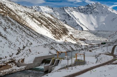 Cajon del Maipo 'nun dramatik manzarası, Yeso Barajı' ndan dökülen su ve baraj karlı dağlarla çevrili.. 