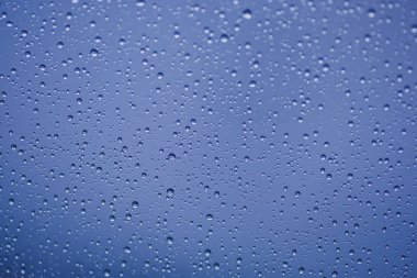 Mavi su damlaları bardağa düşer.