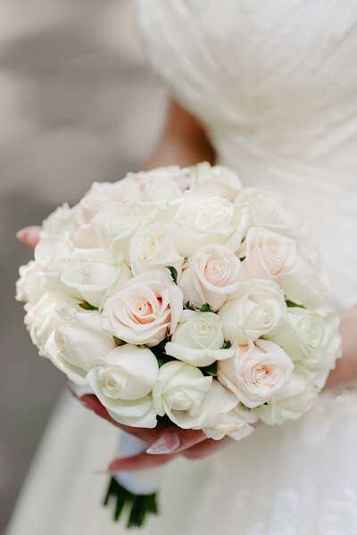 bride holding bouquet of white roses flowers