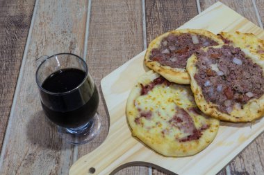 Lezzetli Arapça Esfiha, dolgu peynir ve domates ve soğan ile et. Ahşap bir gemide hizmet.