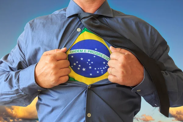 ビジネスの男性彼の シャツを引っ張って開き ブラジル国旗が表示されます 背景には雲と青空 — ストック写真