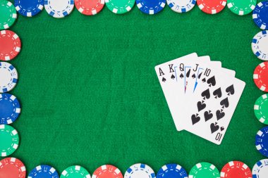 Hand of Poker, straight flush and chips frame on a felt green background. Top view and copy space.