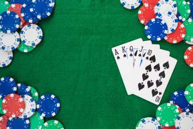 Hand of Poker, straight flush and chips frame on a felt green background. Top view and copy space.
