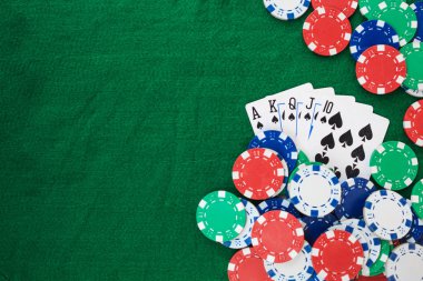 Hand of Poker, straight flush and chips frame on a felt green background. Top view and copy space.