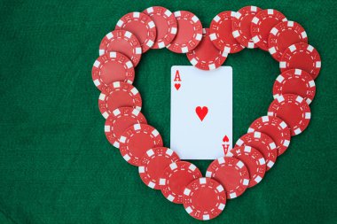 Kupa, bir yeşil arka masada bir ası ile poker fişi ile yapılan kalp. Kopya alanı ile üstten görünüm.