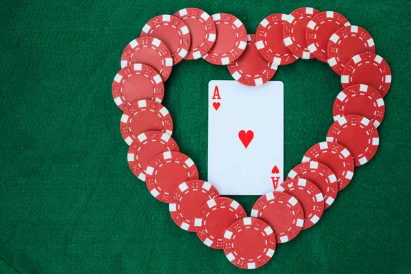 Kupa, bir yeşil arka masada bir ası ile poker fişi ile yapılan kalp. Kopya alanı ile üstten görünüm.