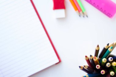 Okul ve çizim malzemeleri, beyaz bckground. Kitap, kalem, silgi ve cetvel renkli uygular. Kopya alanı ile.