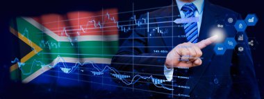 İş adamı KPI finansal grafikleri, sanal arayüzdeki stok ve pazarlama paneli ile veri analiz süreci sistemine dokunuyor. Arka planda Güney Afrika bayrağı.