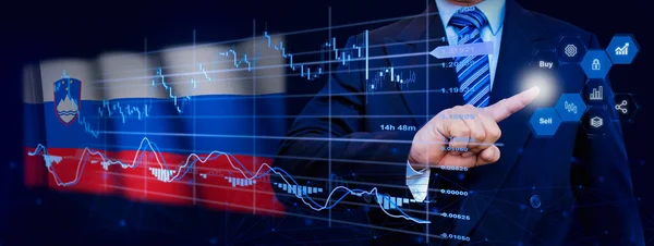 İş adamı KPI finansal grafikleri, sanal arayüzdeki stok ve pazarlama paneli ile veri analiz süreci sistemine dokunuyor. Arka planda Slovenya bayrağı.