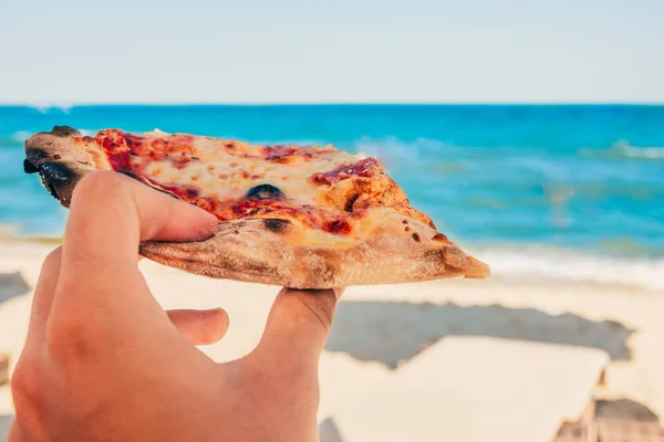 Sahilde pizza yemek.