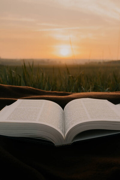 Open bible on sheets at sunrise . morning worship .