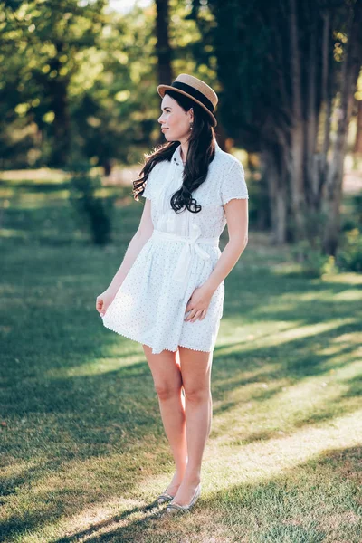 Aantrekkelijk meisje in een hoed en een witte jurk — Stockfoto