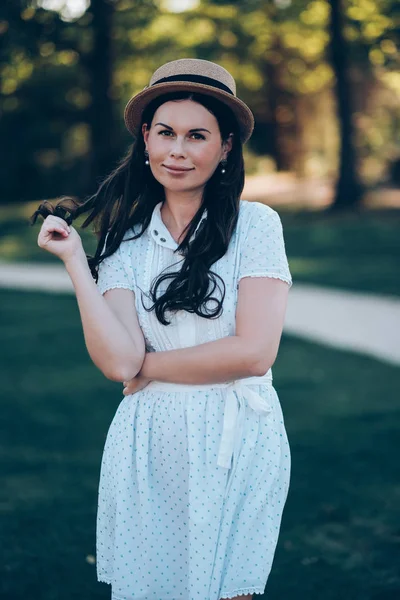 Menina atraente em um chapéu e um vestido branco gosta — Fotografia de Stock