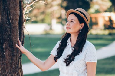 bir şapka ve beyaz elbise li kız sahiptir