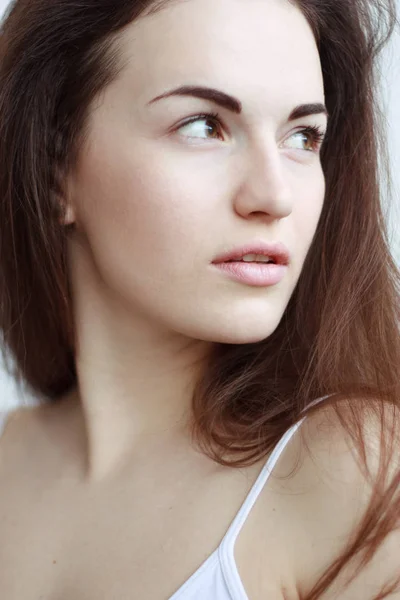 Retrato de cerca de la mujer pensativa con el pelo largo mirando hacia arriba en la luz — Foto de Stock