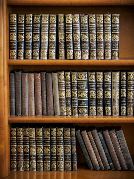 Wooden bookshelf with antique books arranged — Stock Photo, Image