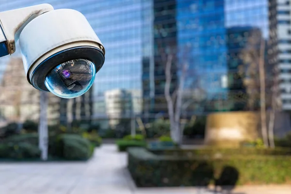 Focus on security CCTV camera or surveillance system with buildings on blurry background