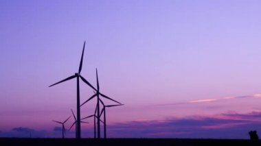güzel bir gün batımı altında kırsalında bir rüzgar çiftliği rüzgar türbini