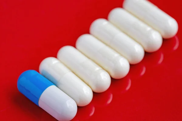 Alignment White Pills White Blue Pill Dark Red Background — Stock Photo, Image