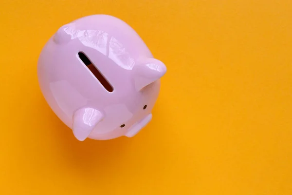 top view of piggy bank isolated on yellow background