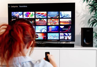 Benon, Fransa - 30 Aralık 2018: Fransızca olarak Prime Video, Amazon.com tarafından oluşturulan bir video-on-demand servis ana görüntüleyen bir ekranı bakan bir tv uzaktan kumanda tutan kadın